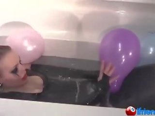 Latex geklede meesteres met ballonnen in een badkuip