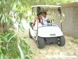 Een schoolmeisje en haar partner zijn driving rond in een golf cart. plotseling zij stoppen en de jeugdig initiates naar aanraken de meisje omhoog,